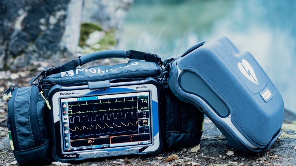 MobiMed monitor tillsammans med hjärtstartare Reanibex 300 på marken vid ett akutfall